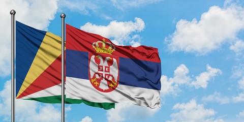 Seychelles and Serbia flag waving in the wind against white cloudy blue sky together. Diplomacy concept, international relations.