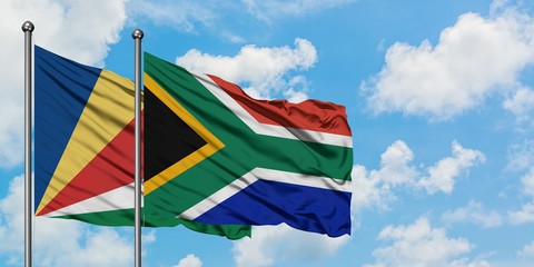 Seychelles and South Africa flag waving in the wind against white cloudy blue sky together. Diplomacy concept, international relations.