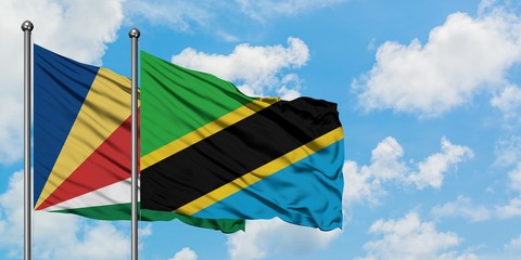 Seychelles and Tanzania flag waving in the wind against white cloudy blue sky together. Diplomacy concept, international relations.