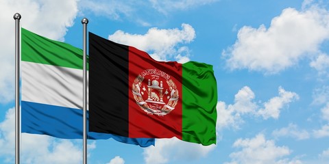 Sierra Leone and Afghanistan flag waving in the wind against white cloudy blue sky together. Diplomacy concept, international relations.