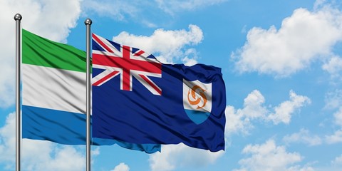 Sierra Leone and Anguilla flag waving in the wind against white cloudy blue sky together. Diplomacy...