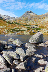 The autumn Pleso nad Skokom lake above the Skok waterfall with rocks in the water near to Strbske lake in Slovakia – Portrait oriented © andras_csontos