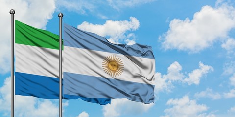 Sierra Leone and Argentina flag waving in the wind against white cloudy blue sky together....