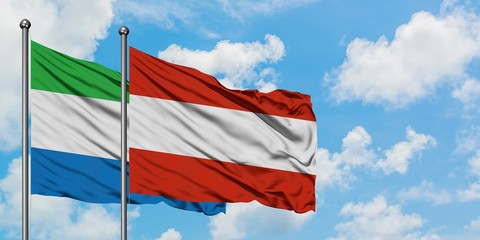 Sierra Leone and Austria flag waving in the wind against white cloudy blue sky together. Diplomacy concept, international relations.