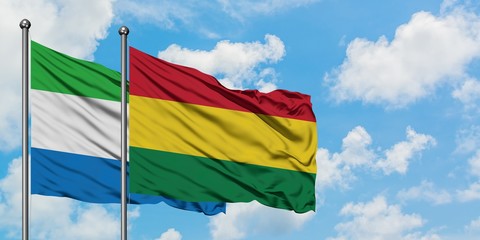 Sierra Leone and Bolivia flag waving in the wind against white cloudy blue sky together. Diplomacy concept, international relations.