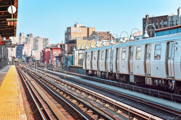 Train arriving at the station in New York City. Buildings in the background, cityscape. Travel and...