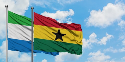 Sierra Leone and Ghana flag waving in the wind against white cloudy blue sky together. Diplomacy concept, international relations.
