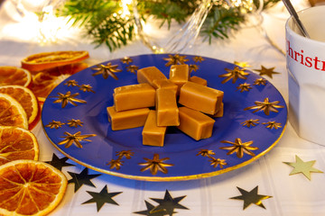 caramelle toffee alla panna su piatto stellato blu fette d'arancia e stelle