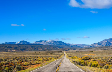 The road intersects the plain and rests against the mountains.