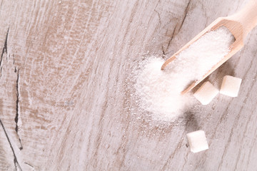 White cane sugar on a light wooden background