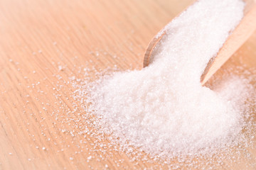 White cane sugar on a light wooden background