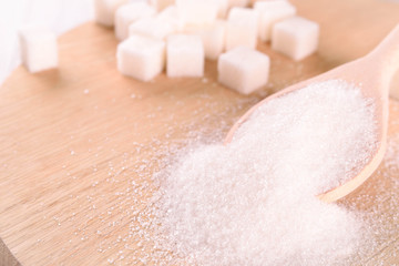 White cane sugar on a light wooden background