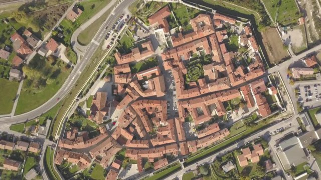 Top down aerial view of a small historic town Venzone in Northern Italy with red tiled roofs of old buildings.