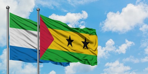 Sierra Leone and Sao Tome And Principe flag waving in the wind against white cloudy blue sky...
