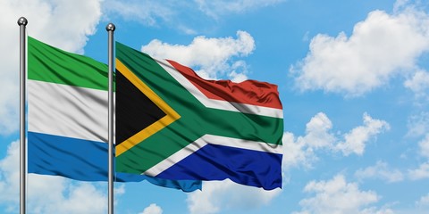 Sierra Leone and South Africa flag waving in the wind against white cloudy blue sky together. Diplomacy concept, international relations.