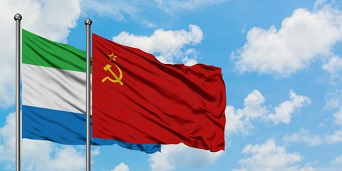 Sierra Leone and Soviet Union flag waving in the wind against white cloudy blue sky together....
