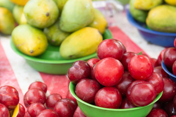 Plums and mangoes piled at the street market