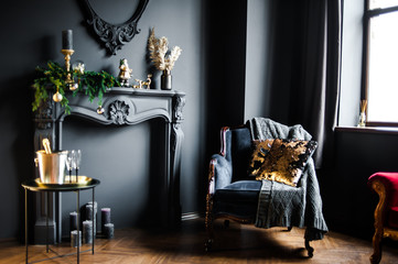 Beautiful dark interior with fake fireplace and armchair