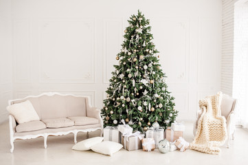 Classic christmas New Year decorated interior room New year tree. Christmas tree with gold decorations. Modern white classical style interior design