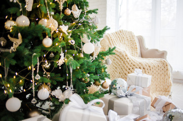 Classic christmas New Year decorated interior room New year tree. Christmas tree with gold decorations. Modern white classical style interior design