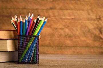 School supplies on a warm, beautiful wooden background. Colored children's pencils in a locker...