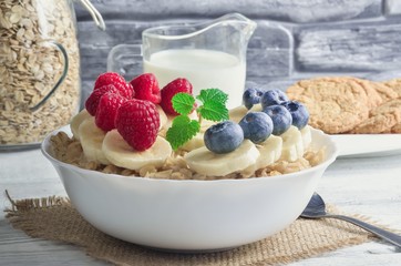 Delicious sweet healthy breakfast. Oatmeal with bananas, blueberries and raspberries.