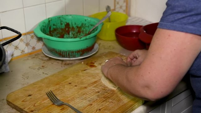 Feminine hands make Apulian panzerotti pies with tomato, mozzarella and prosciutto cotto. Panzerotti is a traditional dish in Salento, Puglia, Italy, fried in olive oil