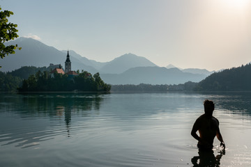 Silhouette of an European man bathing in lake Bled