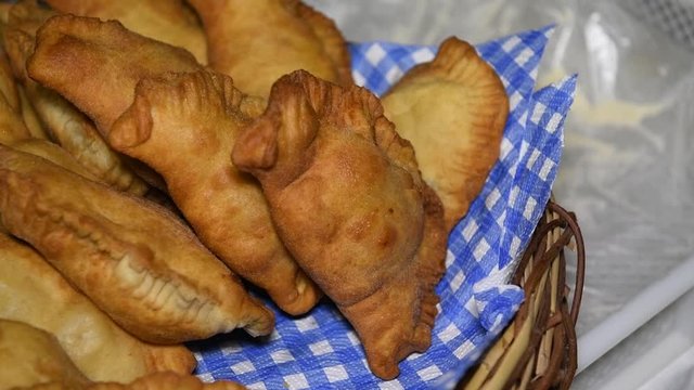Homemade fresh and hot freshly made, Apulian panzerotti with tomato, mozzarella and prosciutto cotto in a basket. Panzerotti is a traditional dish in Salento, Puglia, Italy, fried in olive oil