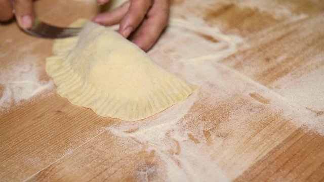 Feminine hands make Apulian panzerotti pies with tomato, mozzarella and prosciutto cotto. Panzerotti is a traditional dish in Salento, Puglia, Italy, fried in olive oil
