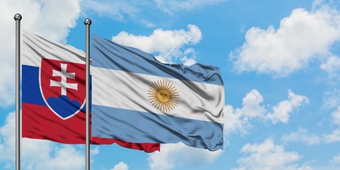 Slovakia and Argentina flag waving in the wind against white cloudy blue sky together. Diplomacy concept, international relations.