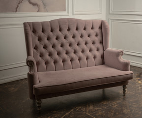 An old sofa on the background of vintage wall