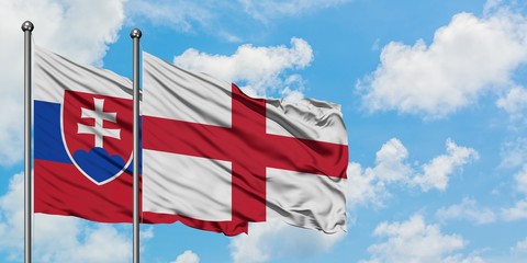 Slovakia and England flag waving in the wind against white cloudy blue sky together. Diplomacy concept, international relations.