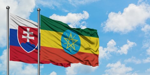 Slovakia and Ethiopia flag waving in the wind against white cloudy blue sky together. Diplomacy...