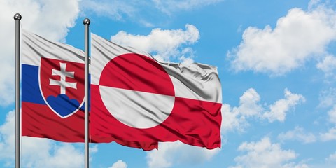 Slovakia and Greenland flag waving in the wind against white cloudy blue sky together. Diplomacy concept, international relations.