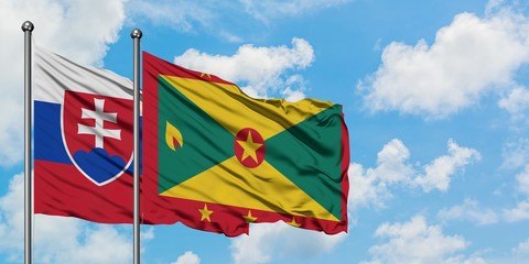 Slovakia and Grenada flag waving in the wind against white cloudy blue sky together. Diplomacy concept, international relations.