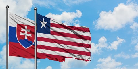 Slovakia and Liberia flag waving in the wind against white cloudy blue sky together. Diplomacy concept, international relations.