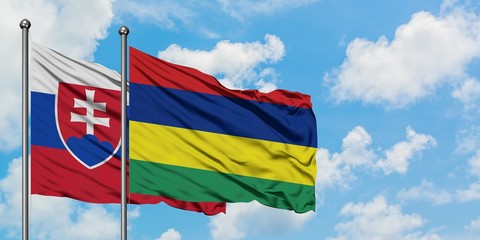 Slovakia and Mauritius flag waving in the wind against white cloudy blue sky together. Diplomacy concept, international relations.