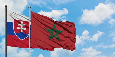 Slovakia and Morocco flag waving in the wind against white cloudy blue sky together. Diplomacy concept, international relations.