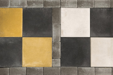 Paving slabs, stones of rectangular and square shapes of different colors laid out with patterns for equipping paths in the country as a background or texture