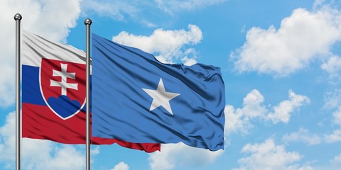 Slovakia and Somalia flag waving in the wind against white cloudy blue sky together. Diplomacy...
