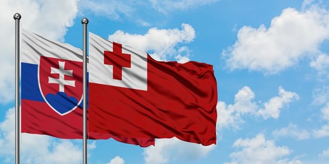 Slovakia and Tonga flag waving in the wind against white cloudy blue sky together. Diplomacy concept, international relations.