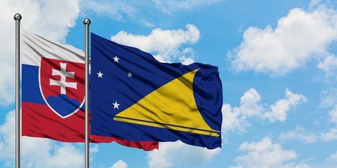Slovakia and Tokelau flag waving in the wind against white cloudy blue sky together. Diplomacy concept, international relations.