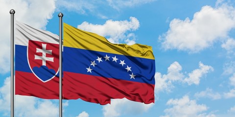Slovakia and Venezuela flag waving in the wind against white cloudy blue sky together. Diplomacy concept, international relations.