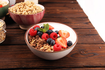 Tasty homemade granola served on table. Healthy breakfast with a bowl of oatmeal with banana, blueberries, strawberries and healthy food for Breakfast