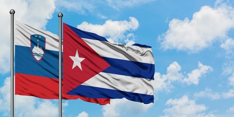 Slovenia and Cuba flag waving in the wind against white cloudy blue sky together. Diplomacy concept, international relations.