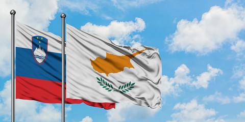 Slovenia and Cyprus flag waving in the wind against white cloudy blue sky together. Diplomacy concept, international relations.