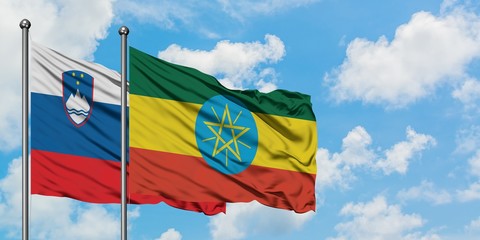 Slovenia and Ethiopia flag waving in the wind against white cloudy blue sky together. Diplomacy concept, international relations.