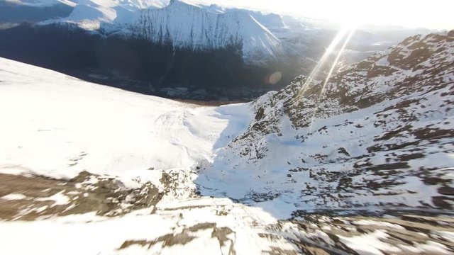 Aerial View of high speed flying down a mountain covered in snow