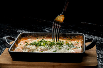 Cooked hot lasagna, in a beautiful cast-iron bowl.